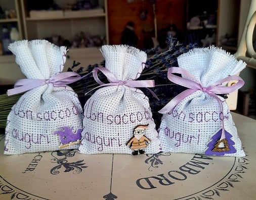 Sacchetti Natalizi. Idee regalo Natale. idee regalo Natale per aziende. Sacchetti con lavanda e frasi auguri. Sacchetti ricamati a punto croce. Sacchetti profumati.  I nostri sacchettini con fiori di lavanda sono ricamati a mano con frasi natalizie. I sacchettini di lavanda sono realizzati a mano e sono un'idea regalo Natale economica e utile.